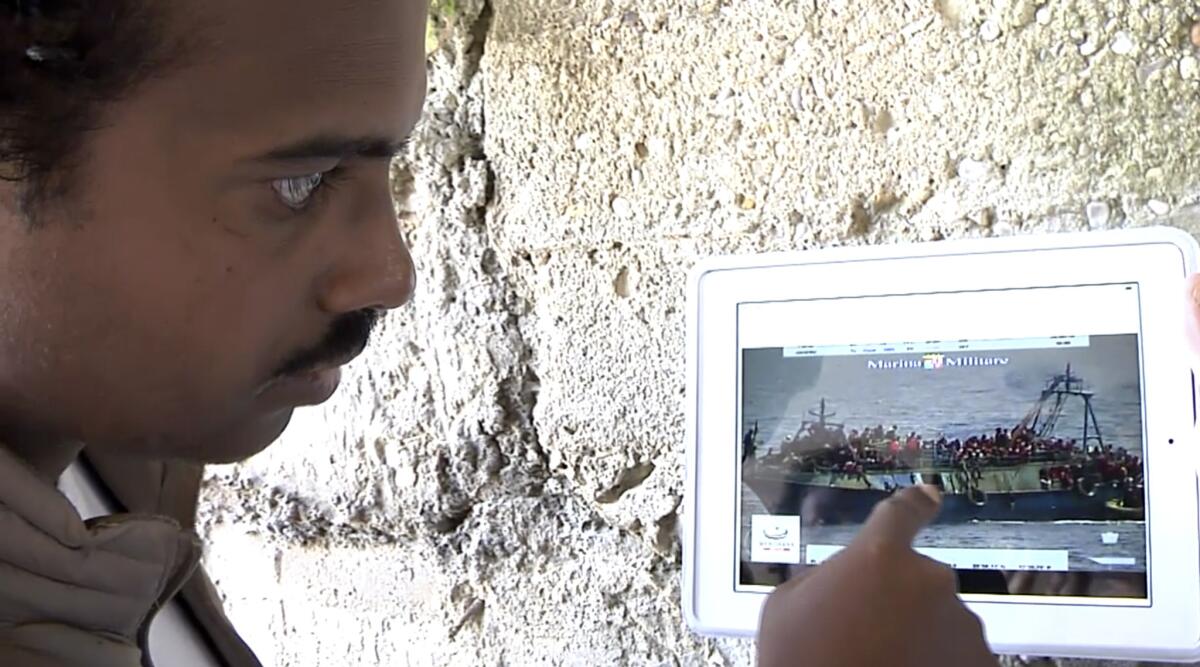Mohammed Ali, from Sudan, points to his location in an Italian navy video showing the capsizing of a smuggler's boat.