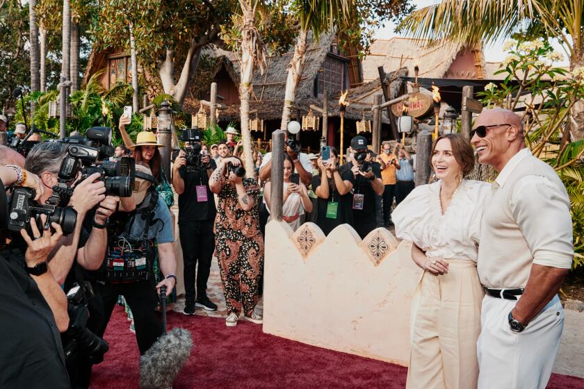 Anaheim, CA - 7/24/21: Emily Blunt and Dwayne Johnson exit the Jungle Cruise ride and pose for photographers on the red carpet for the premiere of the new film Disney's Jungle Cruise Saturday, July 24, 2021 in Disneyland. (PHOTOGRAPH BY ADAM AMENGUAL / FOR THE TIMES)