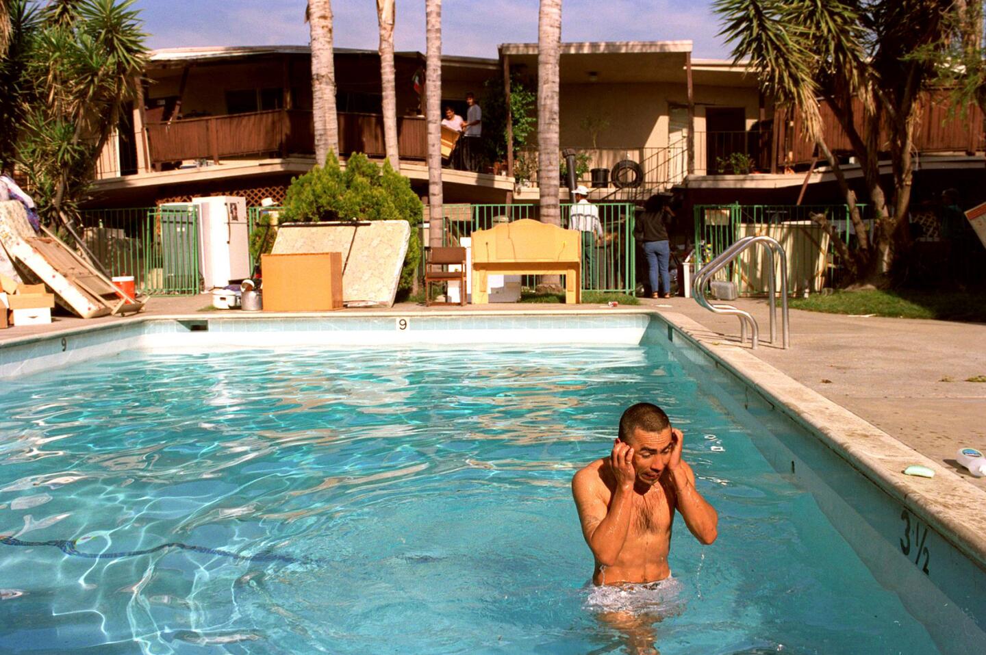 Unable to bathe since his Canoga Park apartment was condemned, Jose Aguilar rinses off in a pool.