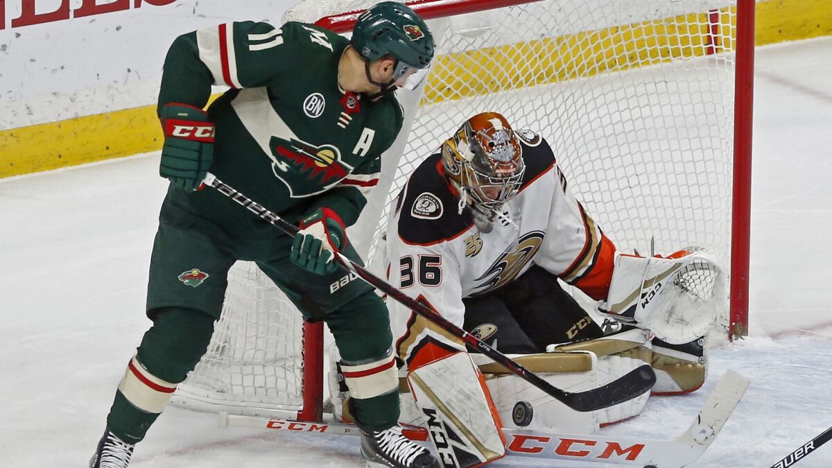Ducks goalie John Gibson, right, stops a scoring attempt by Minnesota Wild's Zach Parise in the first period.