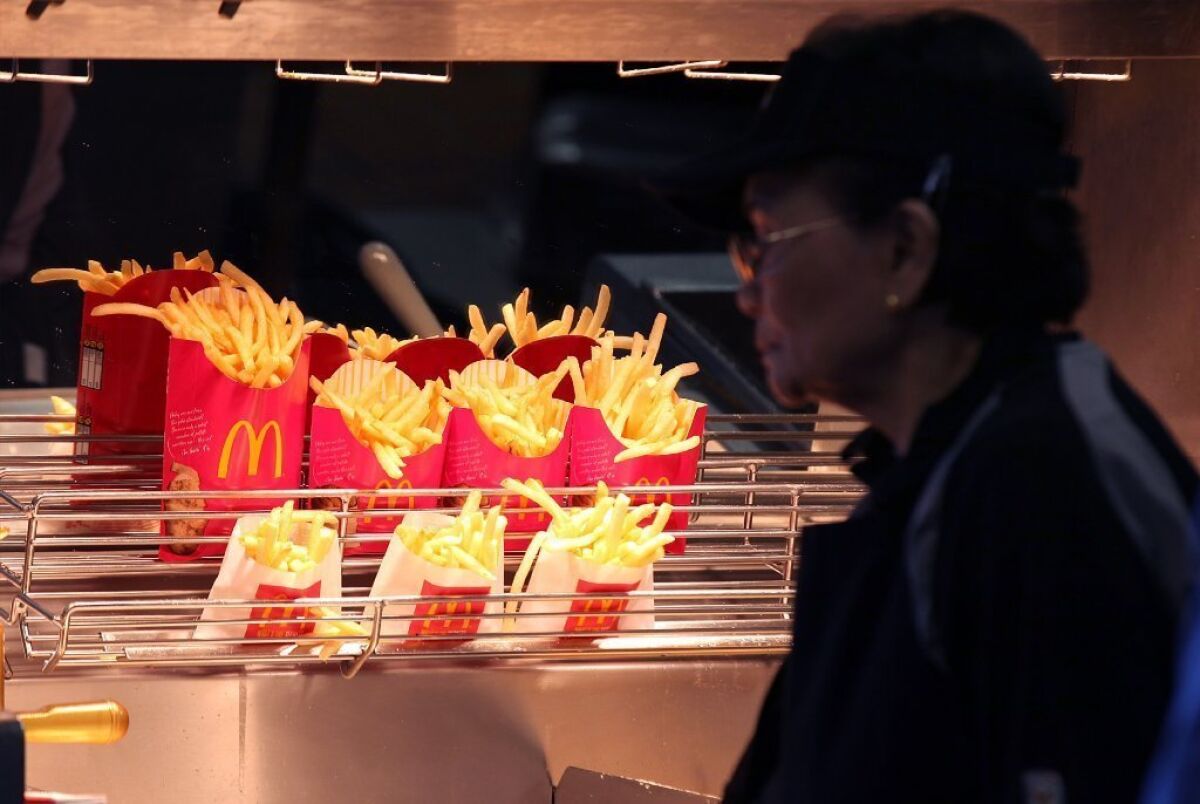 Despite people's best efforts to lose weight by willpower alone, humans are hard-wired to eat as much as possible. Above, McDonald's french fries sit under a heat lamp.