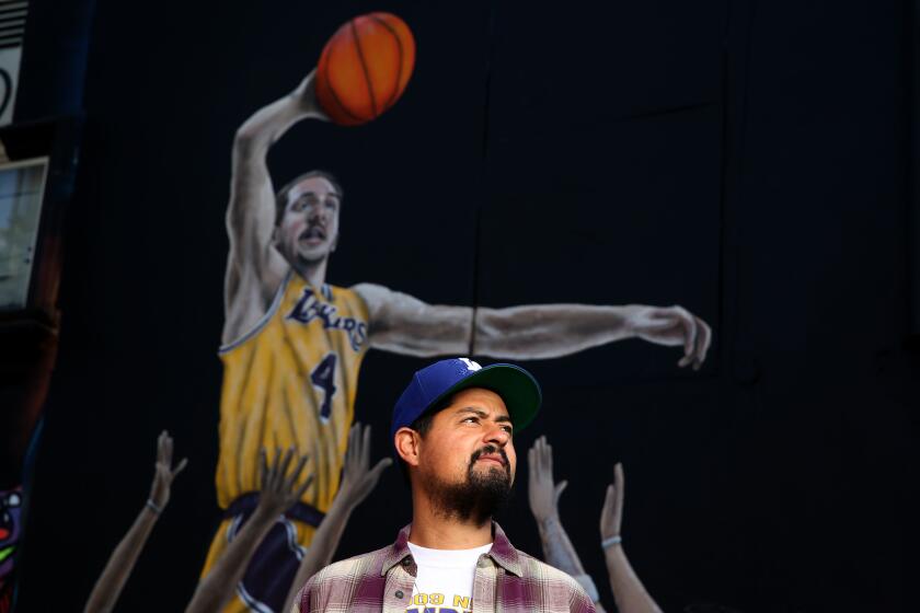 LOS ANGELES, CA-NOVEMBER 22, 2019: Artist Gustavo Zermeño Jr. stands in front of a mural he painted of Lakers guard Alex Caruso and other great basketball players of the west coast in the parking lot of Sportie LA on November 22, 2019, in Los Angeles, California. (Photo By Dania Maxwell / Los Angeles Times)