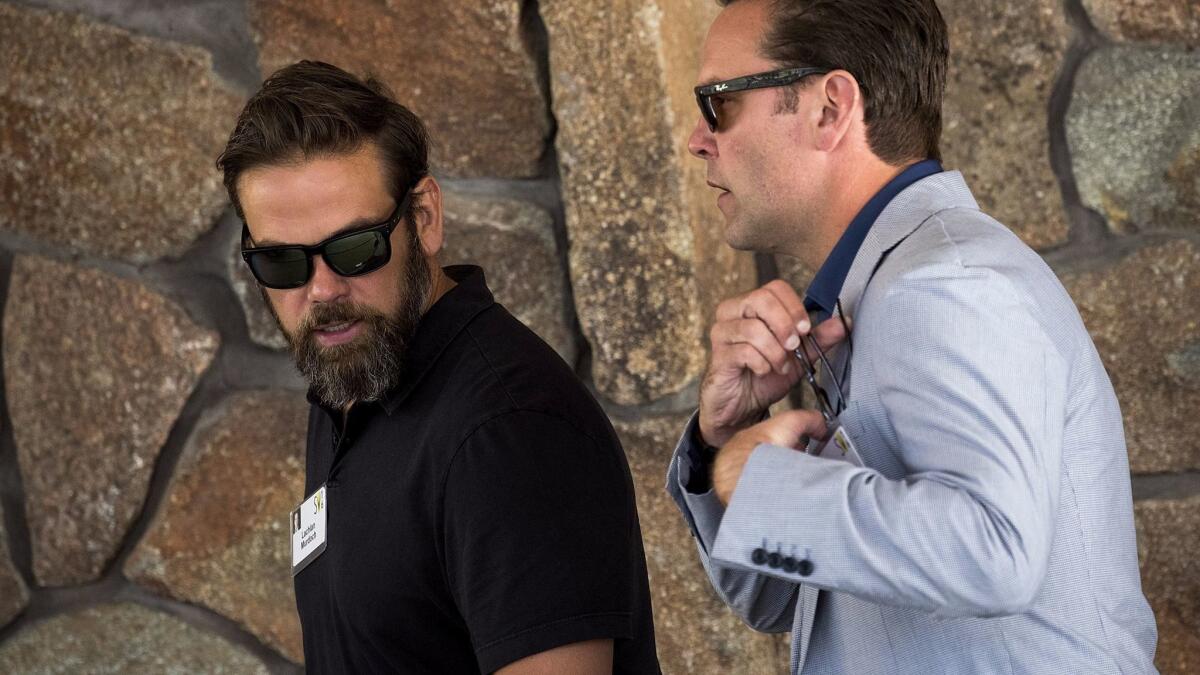 Lachlan Murdoch, left, executive co-chairman of News Corp and 21st Century Fox, walks with brother James Murdoch, chief executive officer of 21st Century Fox, as they attend the annual Allen & Company Sun Valley Conference.