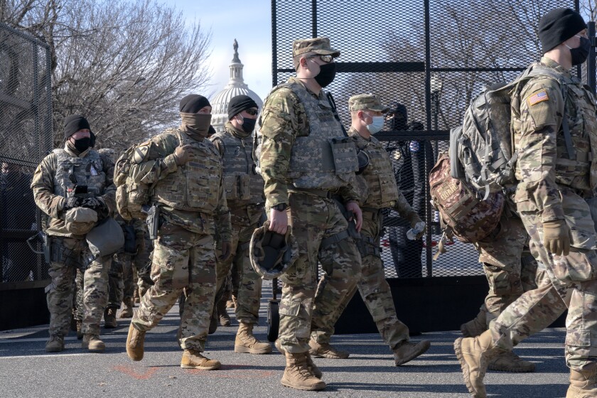 With the U.S. Capitol in the background, members of the National Guard change shifts as they exit through anti-scaling security fencing on Saturday, Jan. 16, 2021, in Washington as security is increased ahead of the inauguration of President-elect Joe Biden and Vice President-elect Kamala Harris. (AP Photo/Jacquelyn Martin)
