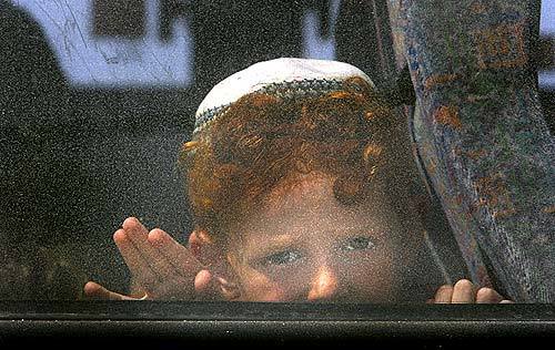 A young Jewish settler from Gush Katif looks out the window of a bus taking him toward the Kissufim Crossing.