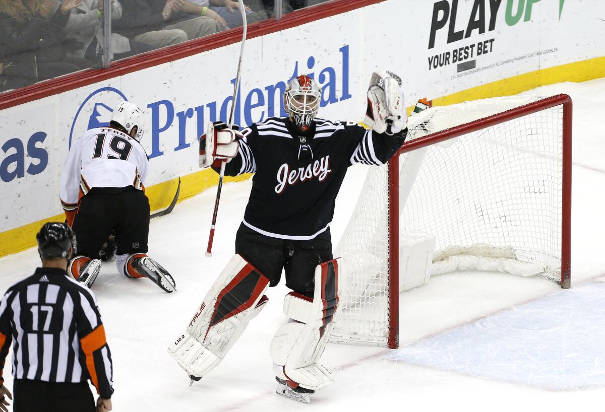 New Jersey Devils goaltender Nico Daws (50) reacts after making a save against Anaheim Ducks right wing Troy Terry (19) during the shootout in an NHL hockey game, Saturday, March 12, 2022, in Newark, N.J. (AP Photo/Noah K. Murray)