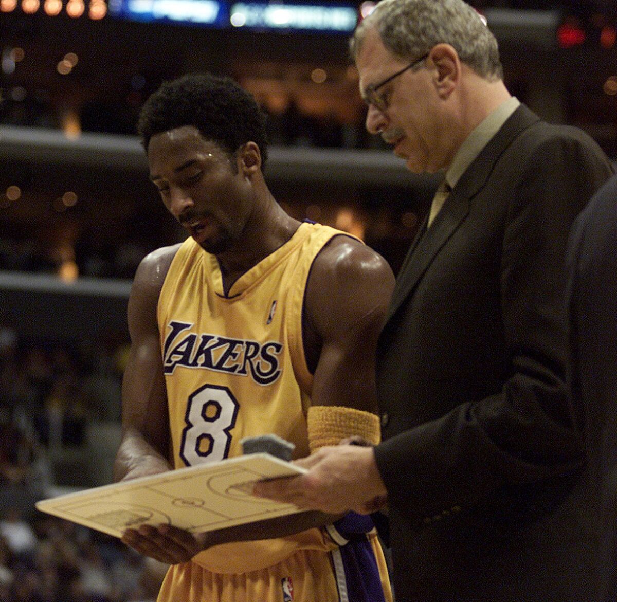 Phil Jackson talks strategy with Kobe during a game in 2000. (Bryan Chan / Los Angeles Times)
