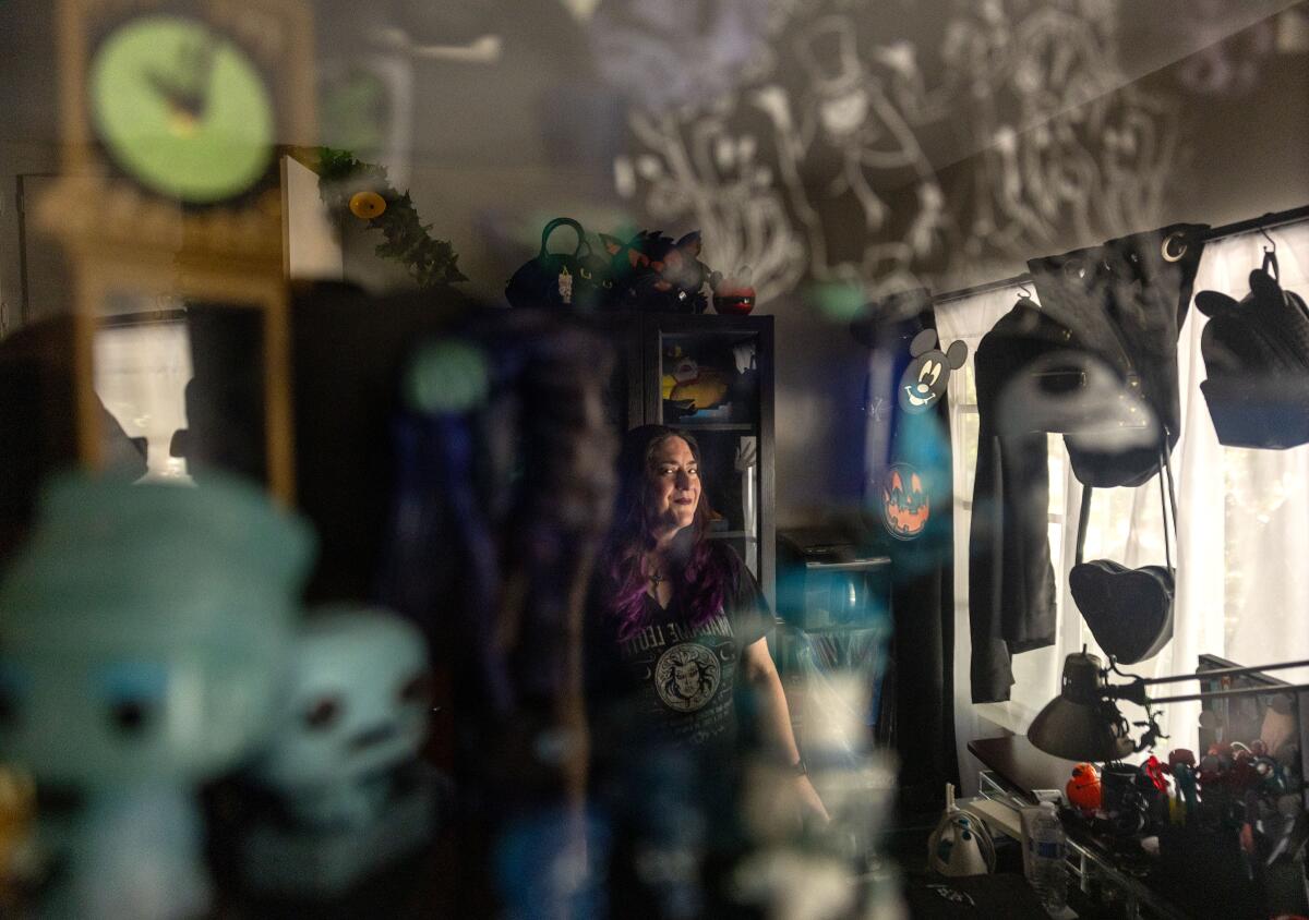 A woman leans on a walker inside her home.