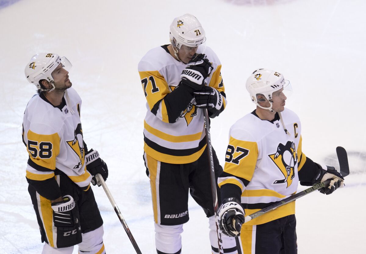 Pittsburgh Penguins center Sidney Crosby (87), center Evgeni Malkin (71) and defenseman Kris Letang (58) react after losing to the Montreal Canadiens in an NHL hockey playoff game Friday, Aug. 7, 2020, in Toronto. (Frank Gunn/The Canadian Press via AP)