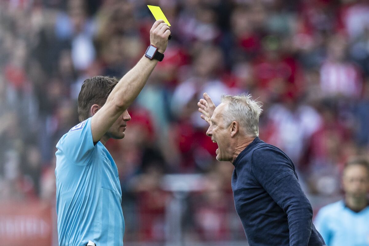Christian Streich sees the yellow card from referee Felix Brych.during a German Bundesliga soccer match between SC Freiburg and Union Berlin in Freiburg, Germany, Saturday, May 7, 2022. (Tom Weller/dpa via AP)