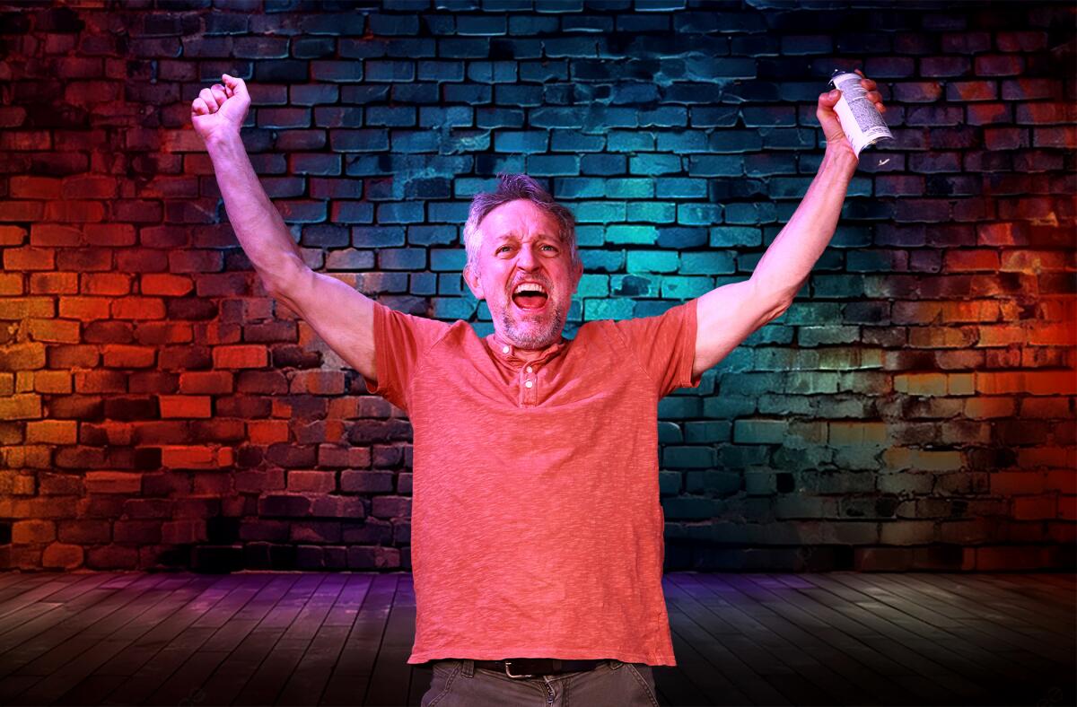 J.D. Cullum raises his arms victoriously, standing in front of a brick wall onstage in "I, Daniel Blake" at Fountain Theatre