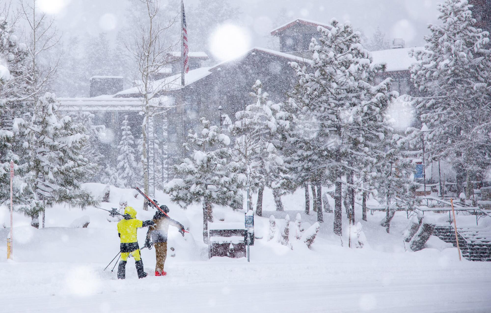 Skiers walking by the lodge astatine Mammoth Mountain.