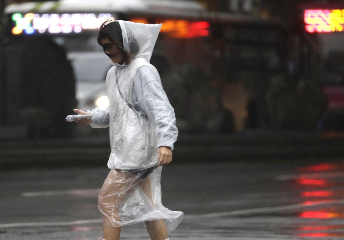 Woman in rain gear walking in wet conditions