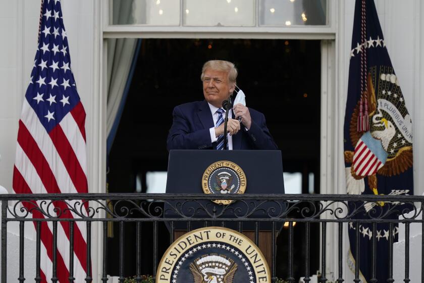 El presidente Donald Trump se retira su mascarilla para pronunciar un discurso desde el balcón del Salón Azul de la Casa Blanca ante partidarios en Washington, el sábado 10 de octubre de 2020. (AP Foto/Alex Brandon)