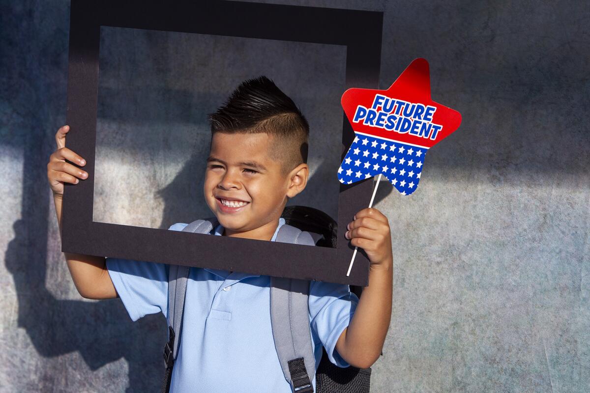 Sol-Ammen Garrido, 5, poses at a photo booth on the first day of school Tuesday at the new International School for Science and Culture charter school in Costa Mesa.