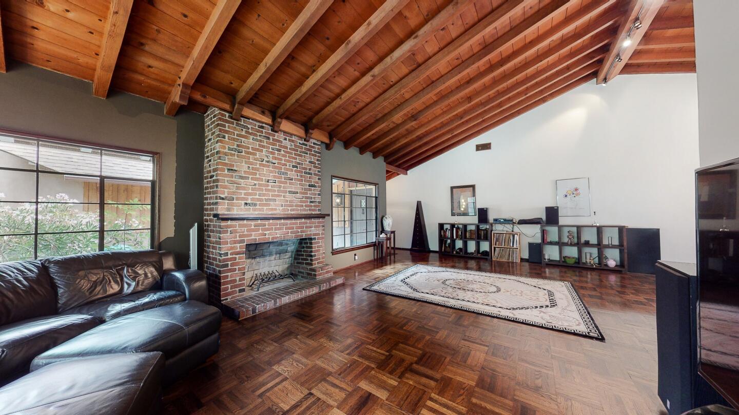 A brick fireplace anchors the living room.