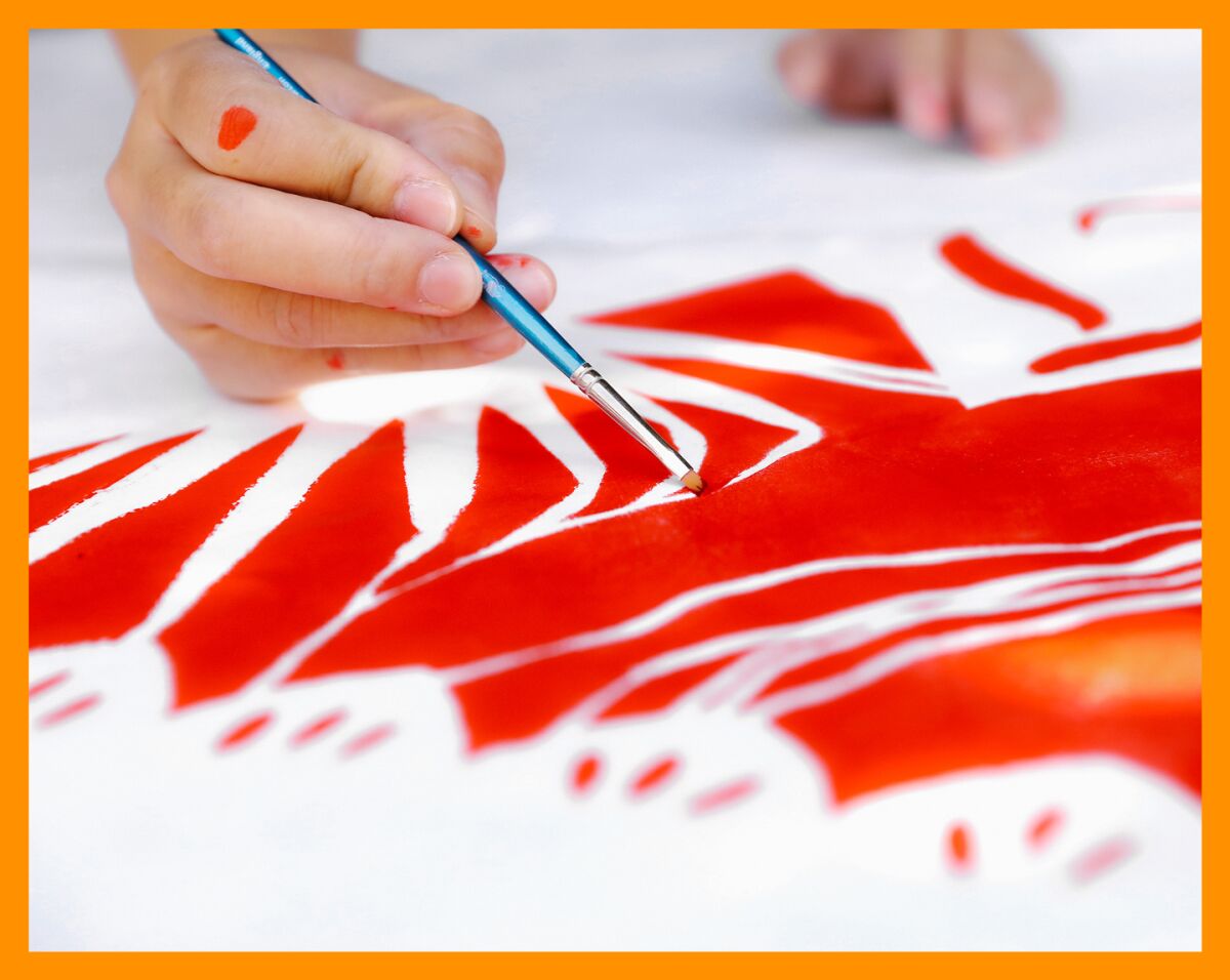 An artist painting with red paint