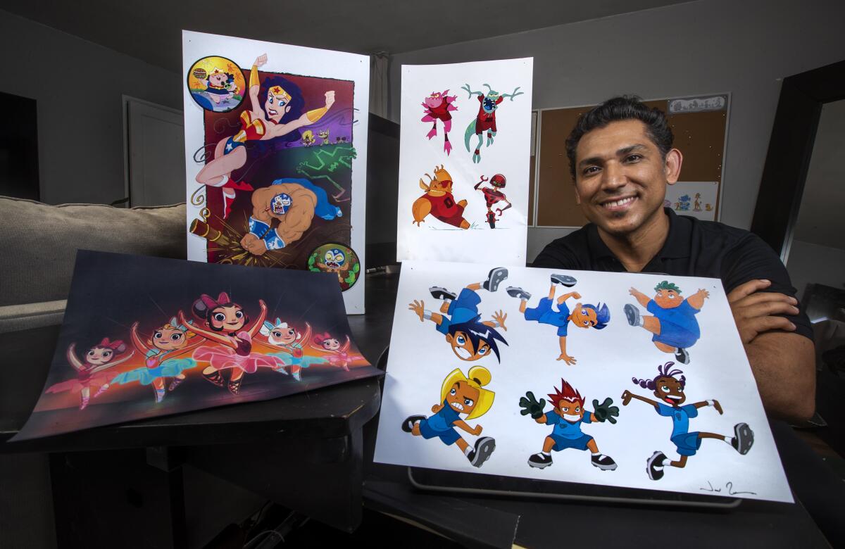 Artist José Zelaya with four boards depicting color drawings of characters at his home in Burbank