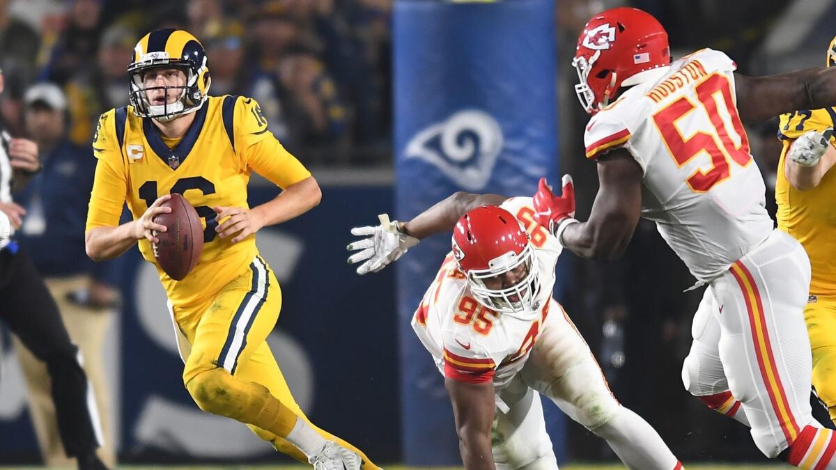 Rams quarterback Jared Goff scrambles away form Chiefs defenders Chris Jones (95) and Justin Houston in the second quarter at the Coliseum.
