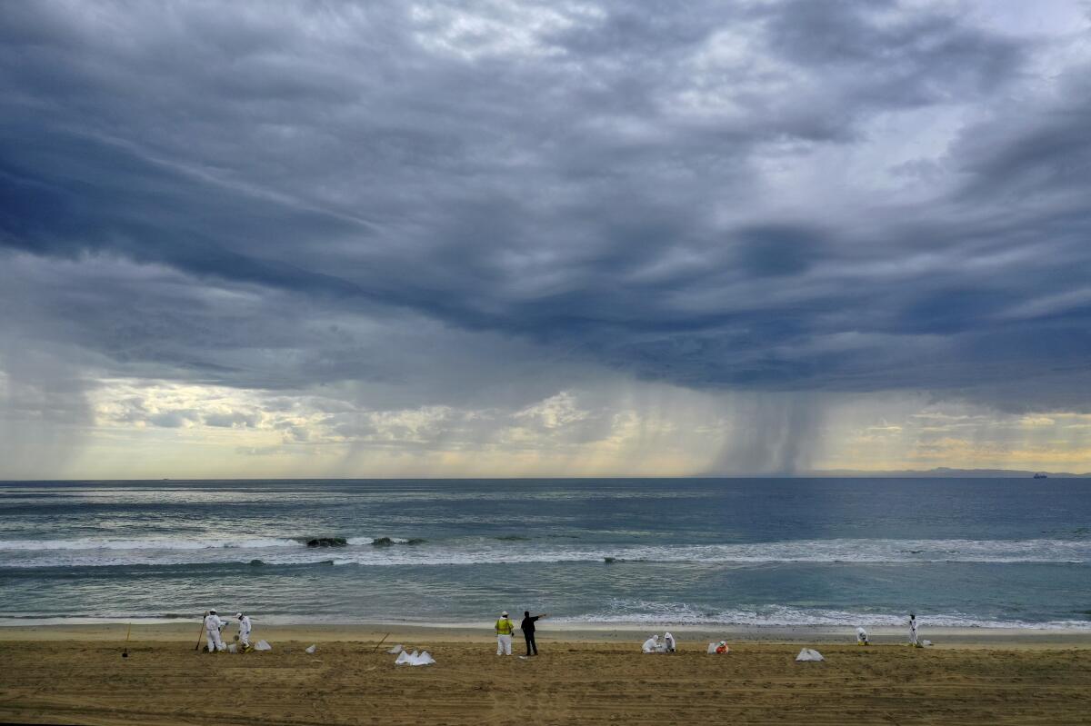 A storm rolls in as cleanup crews spread out across the beach