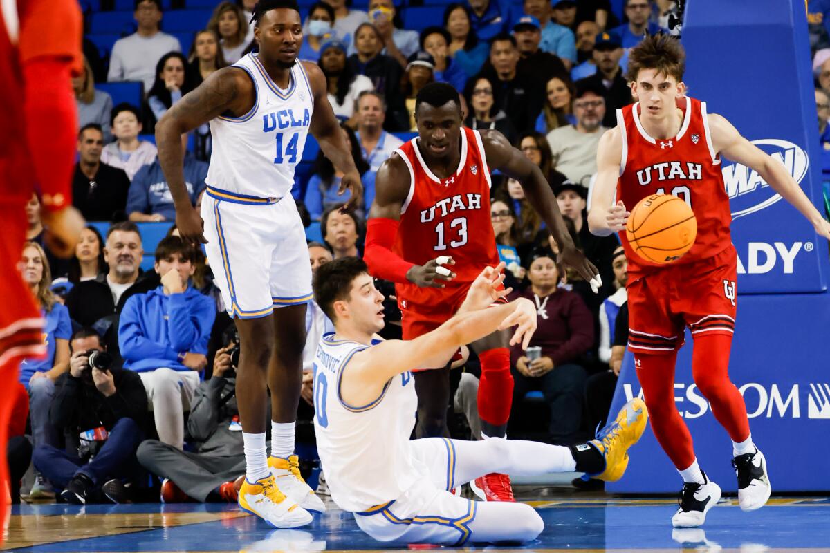 UCLA guard Lazar Stefanovic passes the ball in front of Utah center Keba Keita (13) after diving for a loose ball.