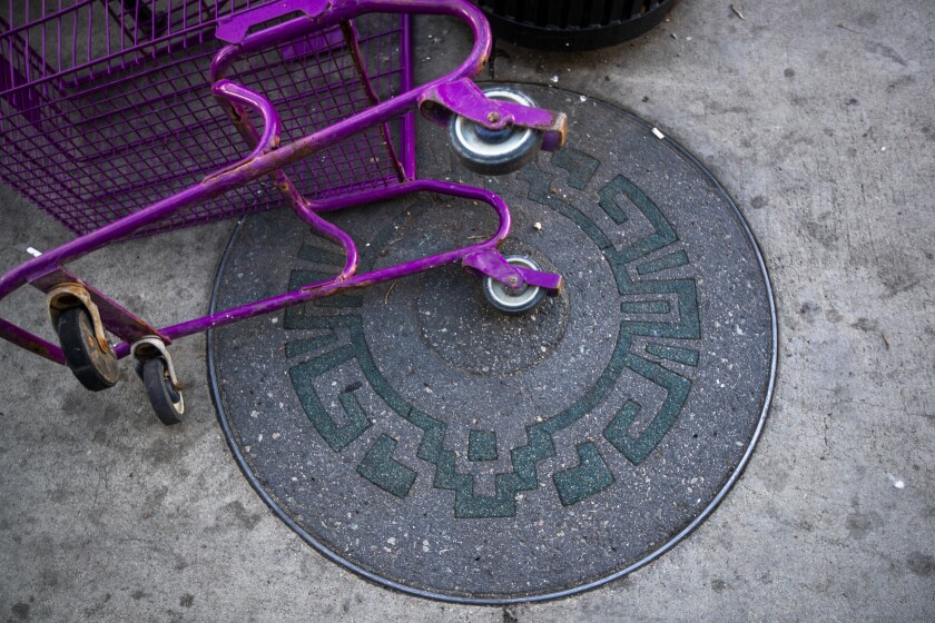 A shopping cart lays on one of dozens of rubber-filled slots with an Aztec design built for future plaques