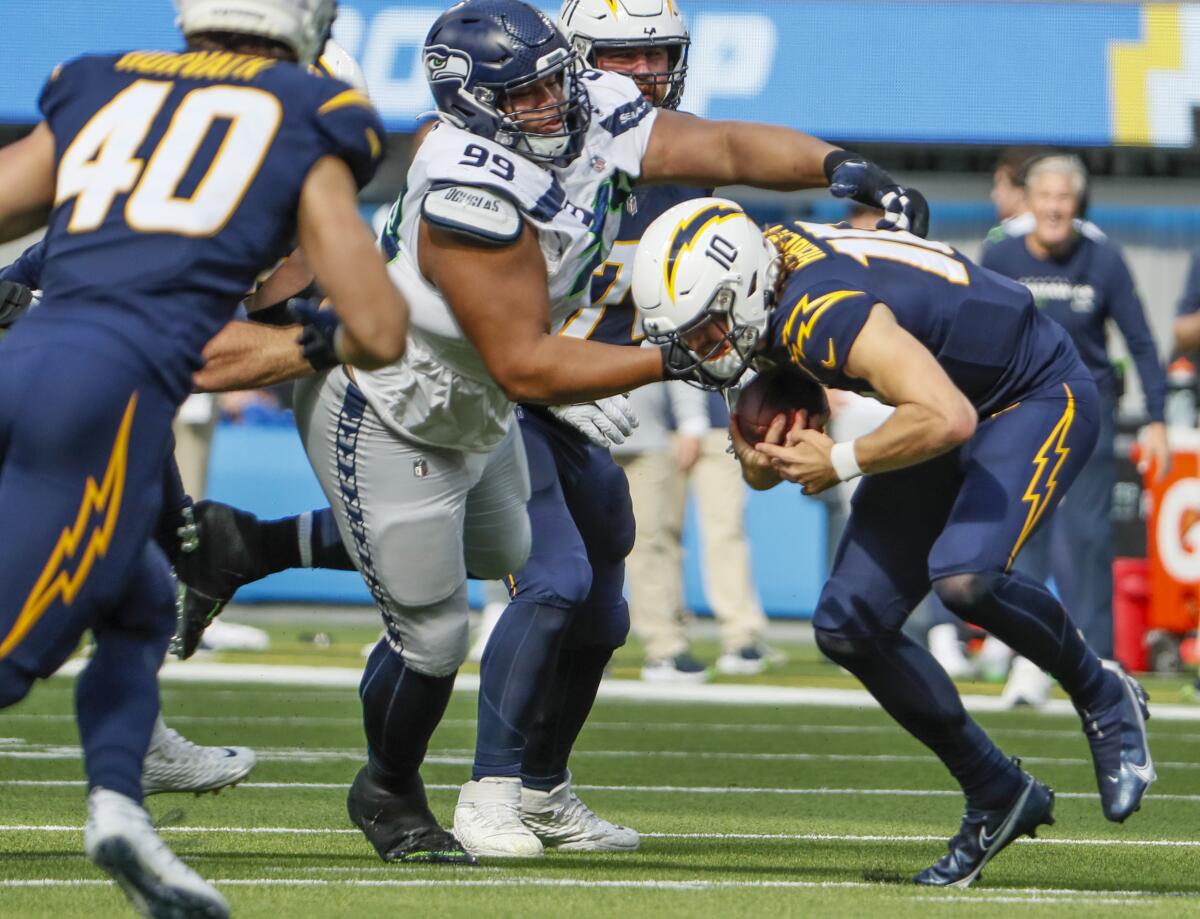 Seattle Seahawks defensive tackle Al Woods sacks Chargers quarterback Justin Herbert.