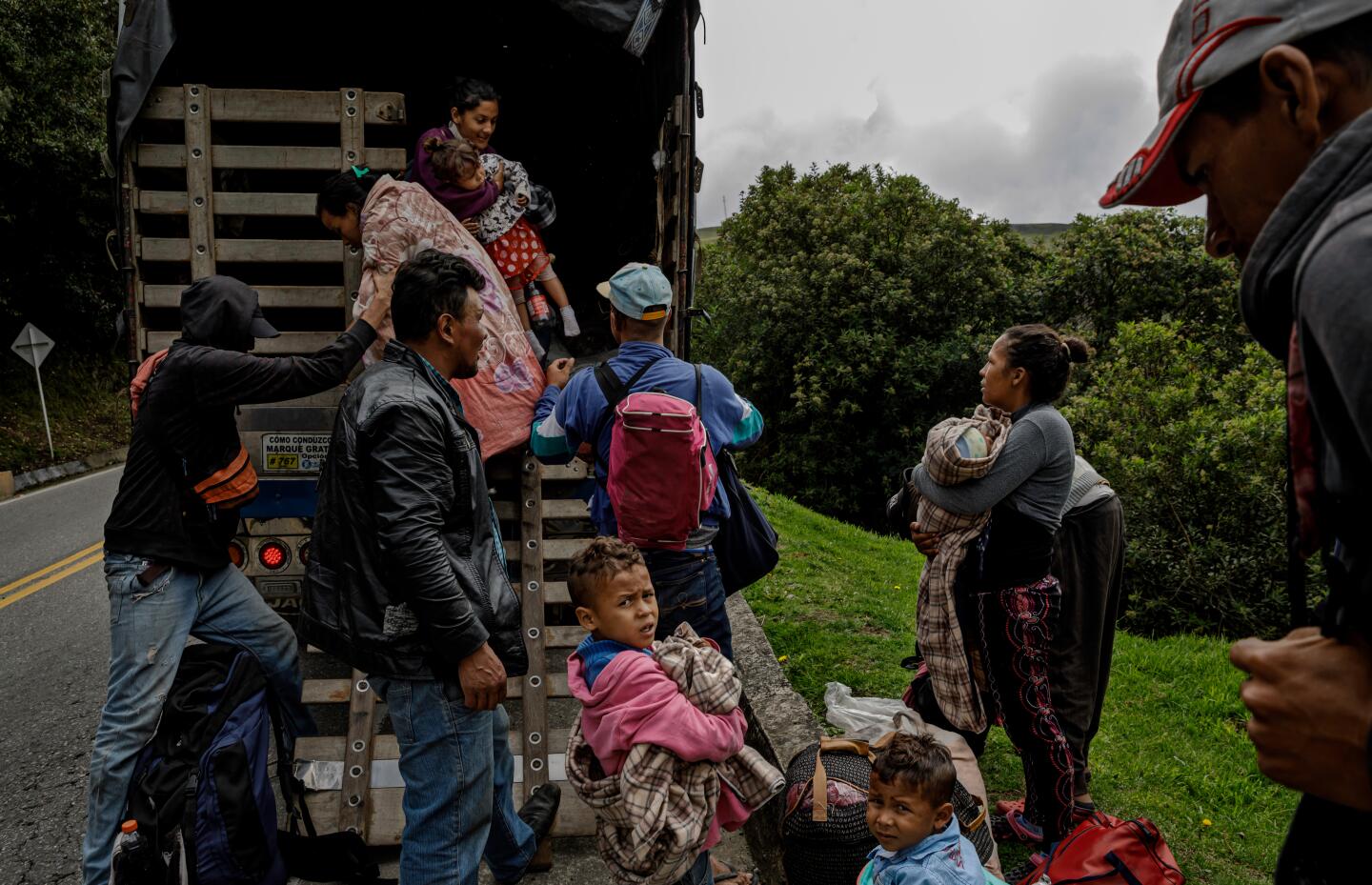 Venezuelan migrants disembark from a truck after getting a ride through the Colombian countryside.