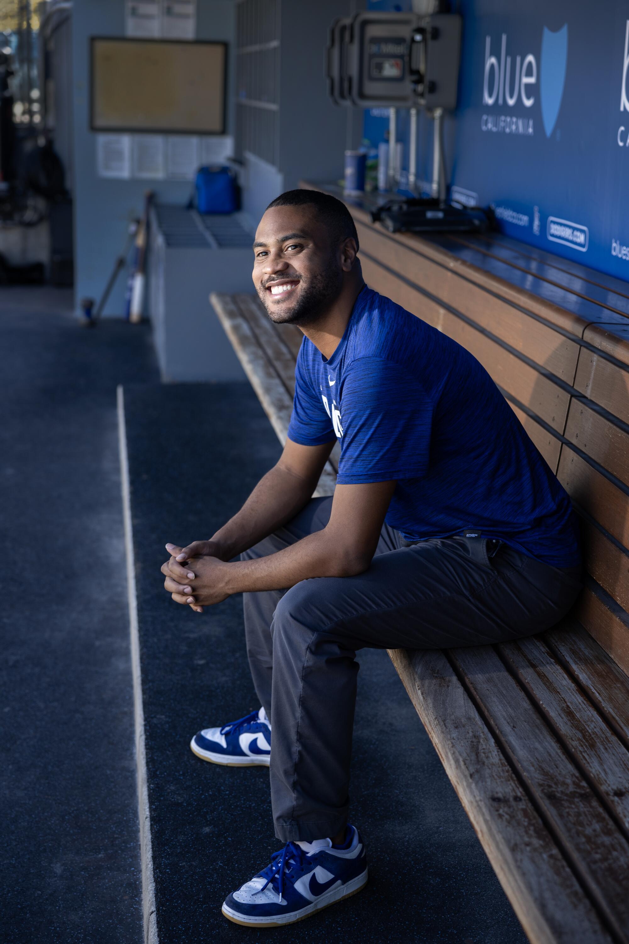 RJ Peete smiles while sitting in the Dodgers dugout.