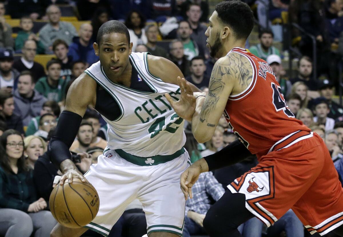 El dominicano Al Horford, de los Celtics de Boston, a la izquierda, intenta pasar a Denzel Valentine, de los Bulls de Chicago, en el primer periodo del partido de la NBA en Boston, el domingo 12 de marzo de 2017. Los Celtics ganaron 100-80 a los Bulls.