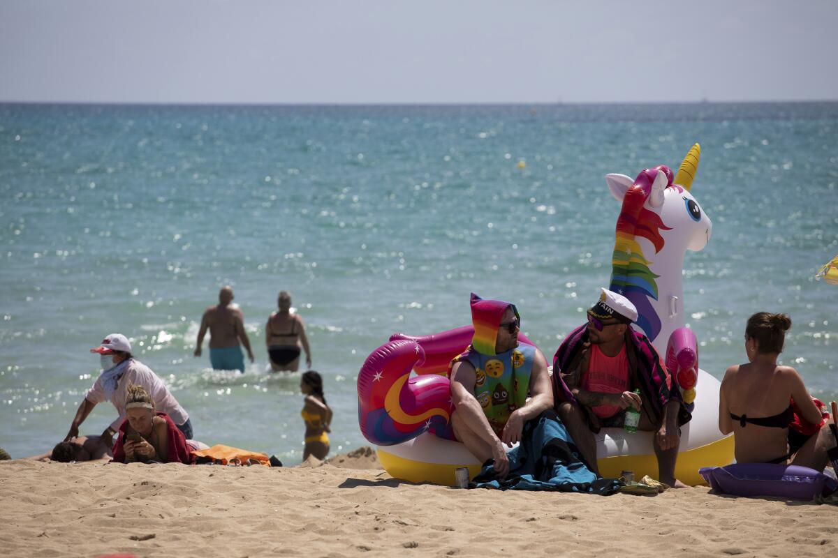 Tourists sunbathe on the beach at the Spanish Balearic Island of Mallorca.