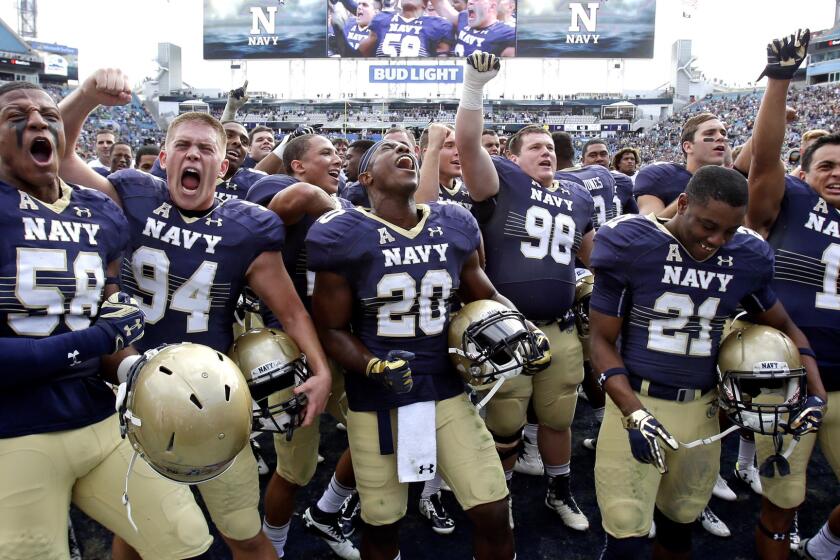 Navy players celebrate after defeating Notre Dame, 28-27, on Saturday.