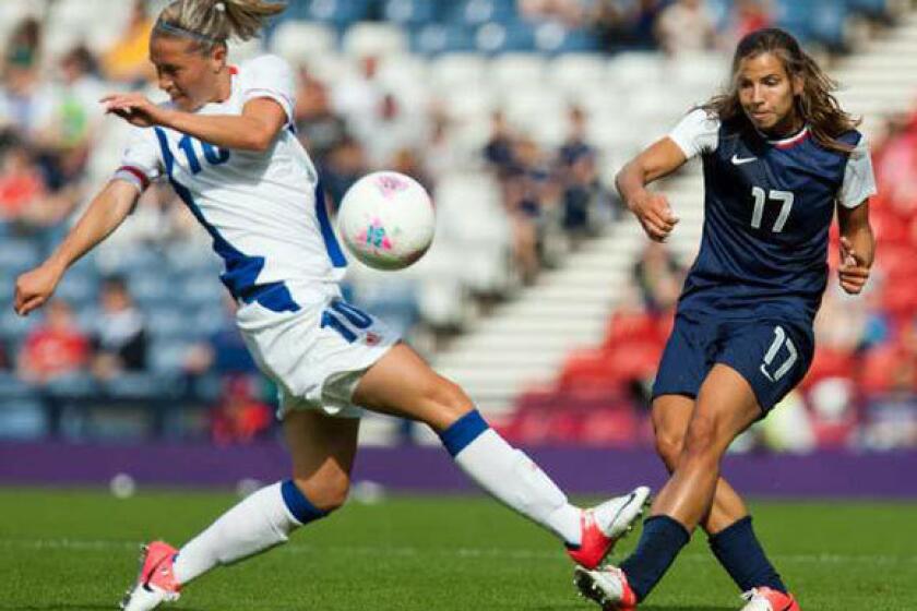 France's Camille Abily, left, attempts to stop a shot by Tobin Heath of the U.S.