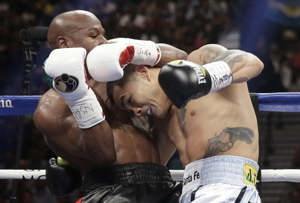 Floyd Mayweather Jr., left, and Marcos Maidana are waging a war of words after a rough-and-tumble bout in May.