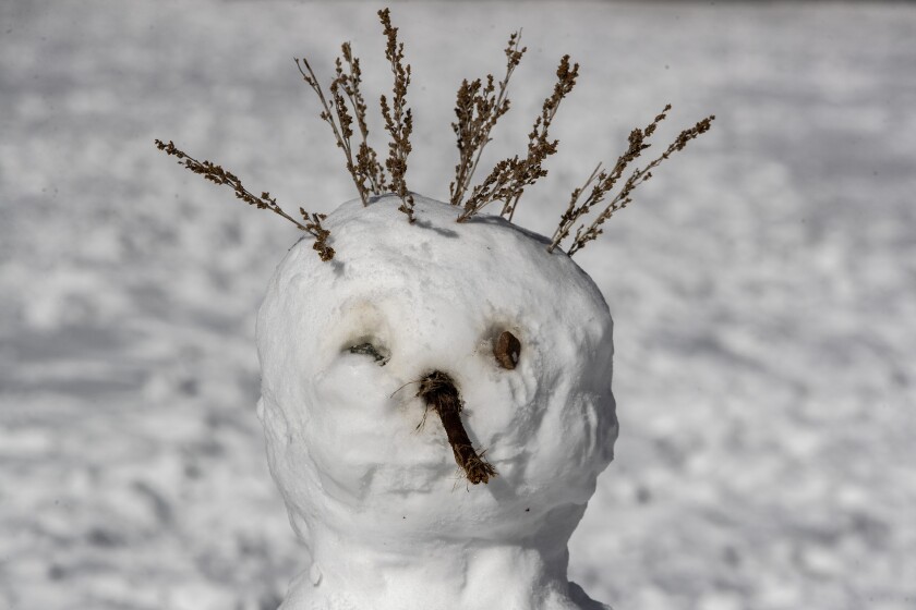 A snowman sits on the beach at Big Bear Lake