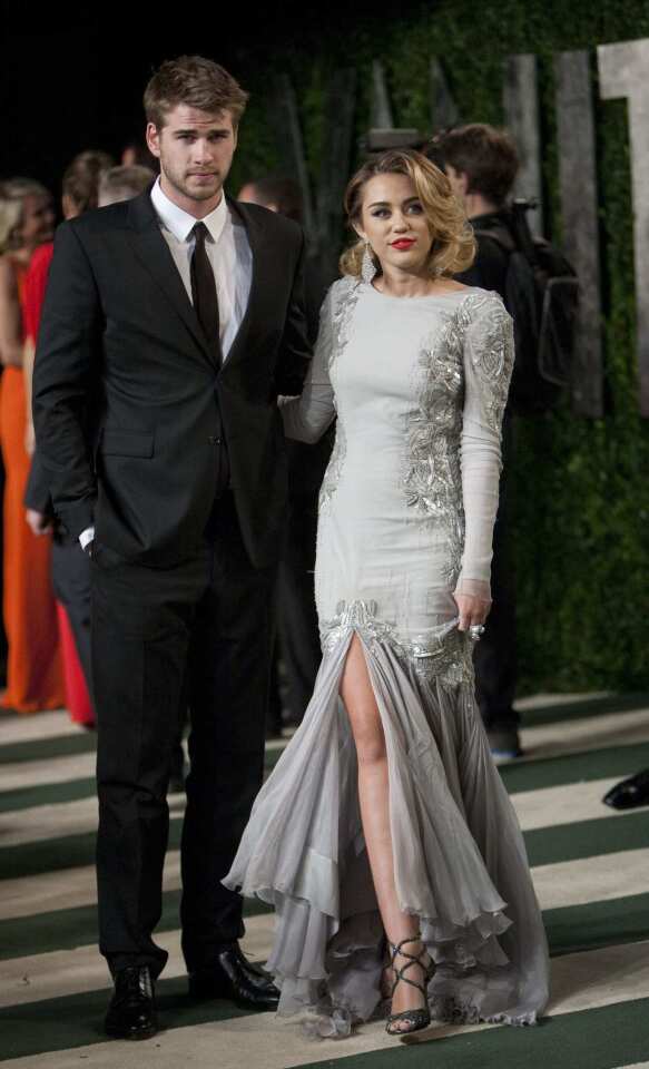 Miley Cyrus, right, and her guest arrive at the Vanity Fair party.