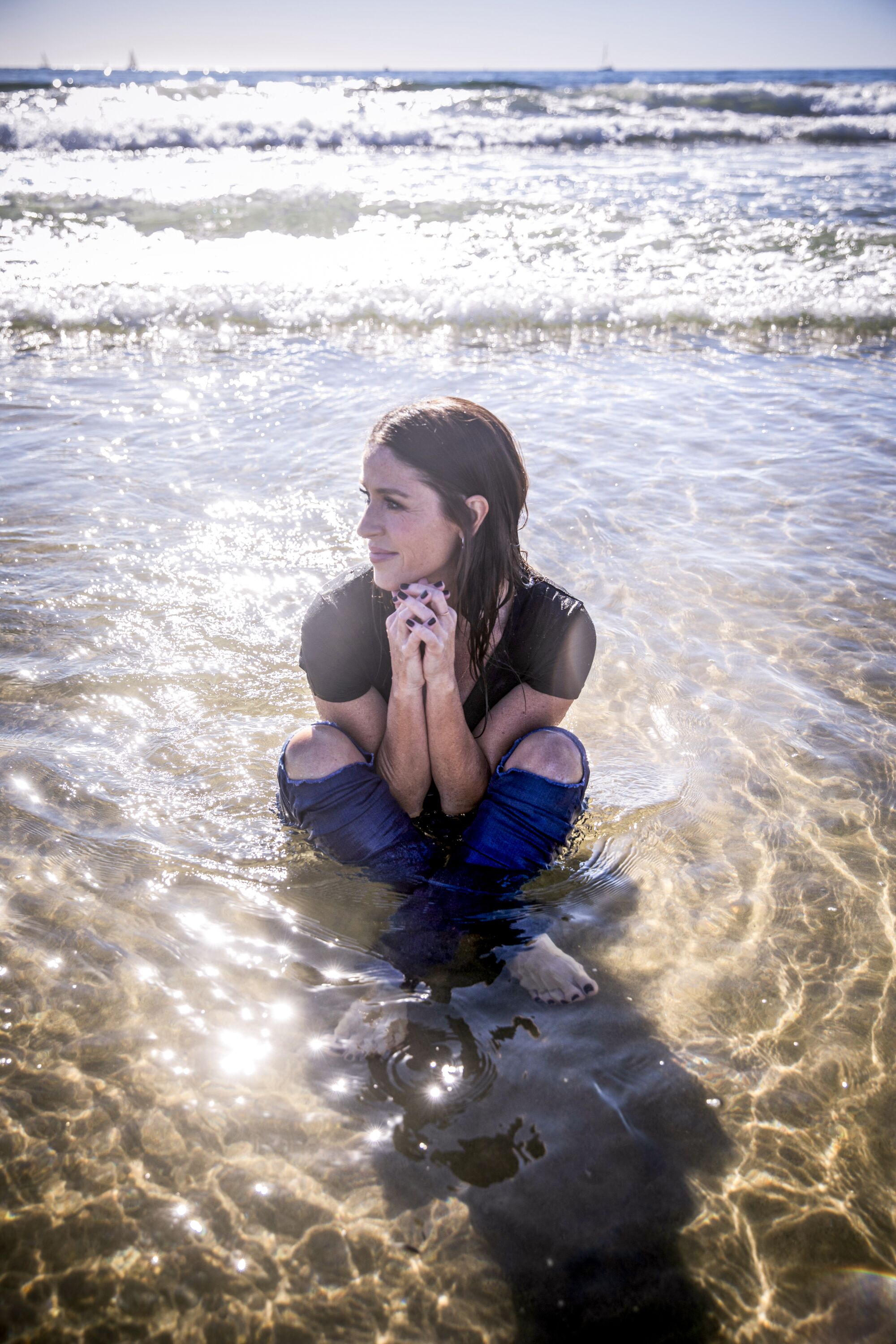Feb. 21: Actress Soleil Moon Frye sits in the water at the beach as the tide rolls in