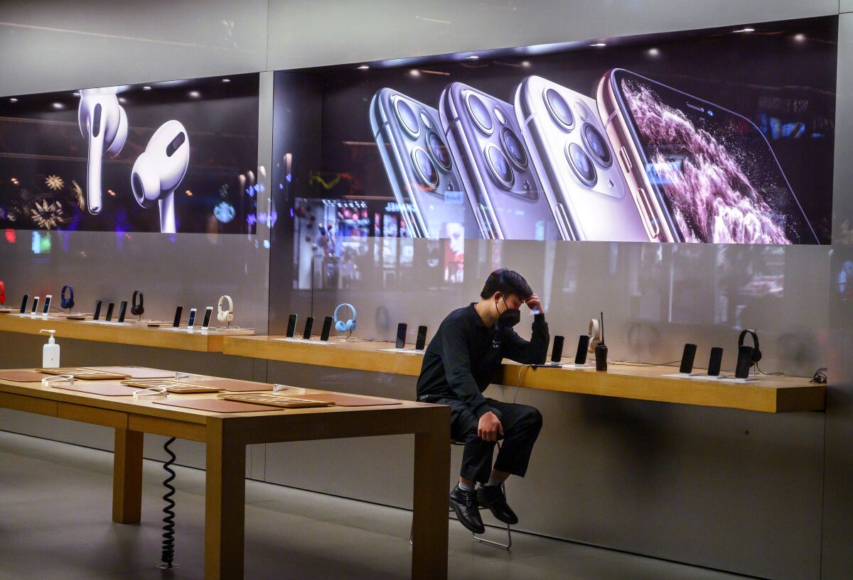 An Apple Store employee in Beijing on Feb. 1, shortly before Apple closed all its stores in China.