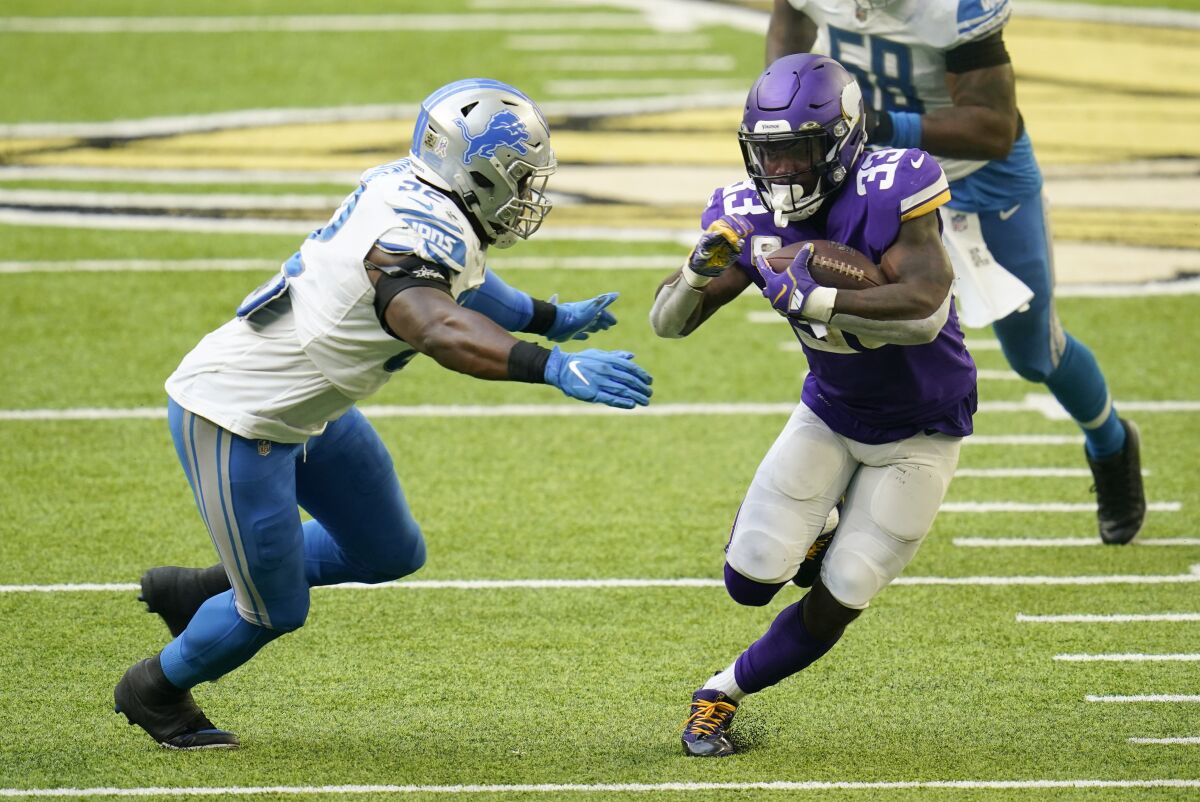 Minnesota Vikings running back Dalvin Cook tries to run past Detroit Lions linebacker Christian Jones.