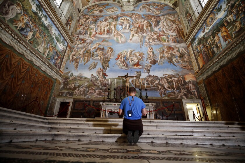 A visitor kneels in front of the Last Judgement fresco by the Italian Renaissance painter Michelangelo inside the Sistine Chapel of the Vatican Museums on the occasion of the museum's reopening, in Rome, Monday, May 3, 2021. The Vatican Museums reopened Monday to visitors after a shutdown following COVID-19 containment measures. (AP Photo/Alessandra Tarantino)