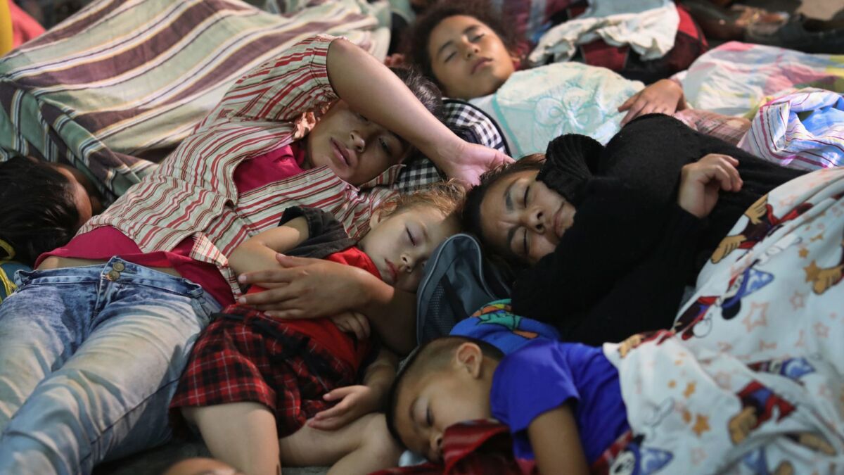 Families of immigrants, part of a migrant caravan of more than 1,500 people, rest for the night in a community gym on Tuesday in Chiquimula, Guatemala.