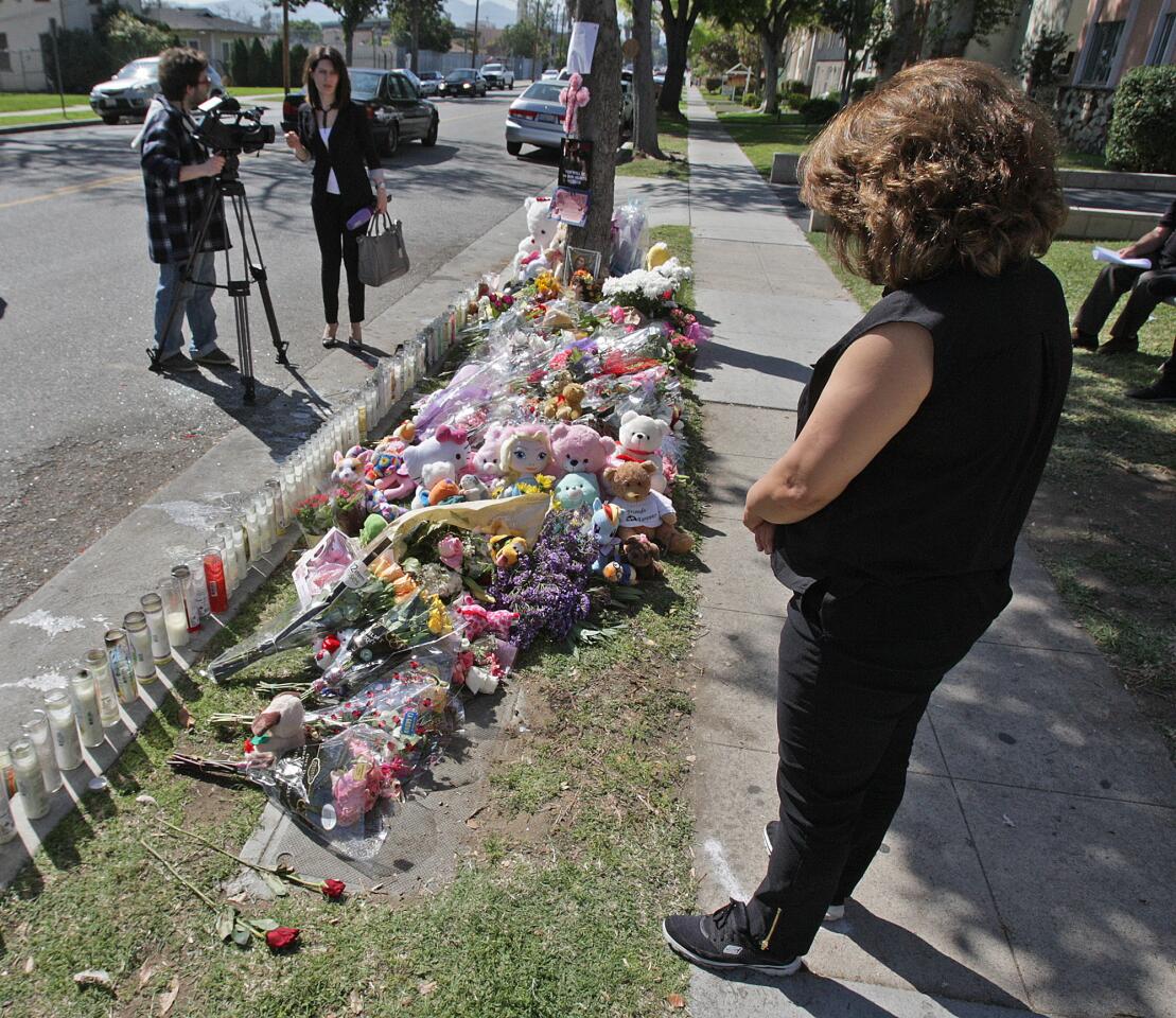 A neighbor, who preferred to be unidentified, stops for a moment to reflect at a memorial for 4-year-old Violeta Khachatoorians in Glendale on Monday, March 9, 2015. 4-year-old Violeta was killed Friday by a hit-and-run driver who turned himself in over the weekend.