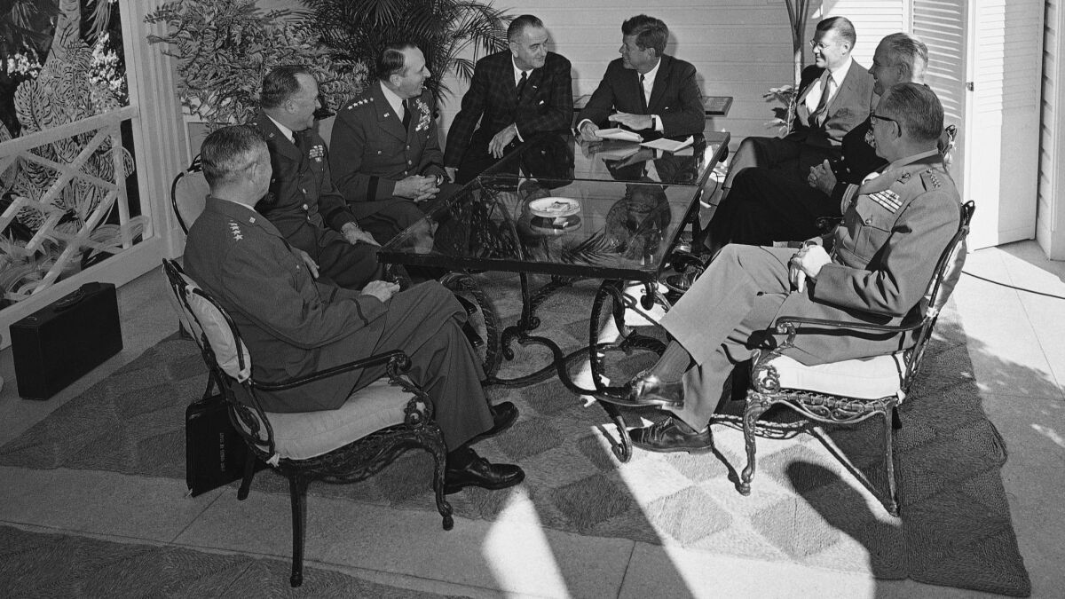 President John F. Kennedy and Vice President Lyndon B. Johnson talk to military advisers on the patio of Kennedy's winter White House in Palm Beach.