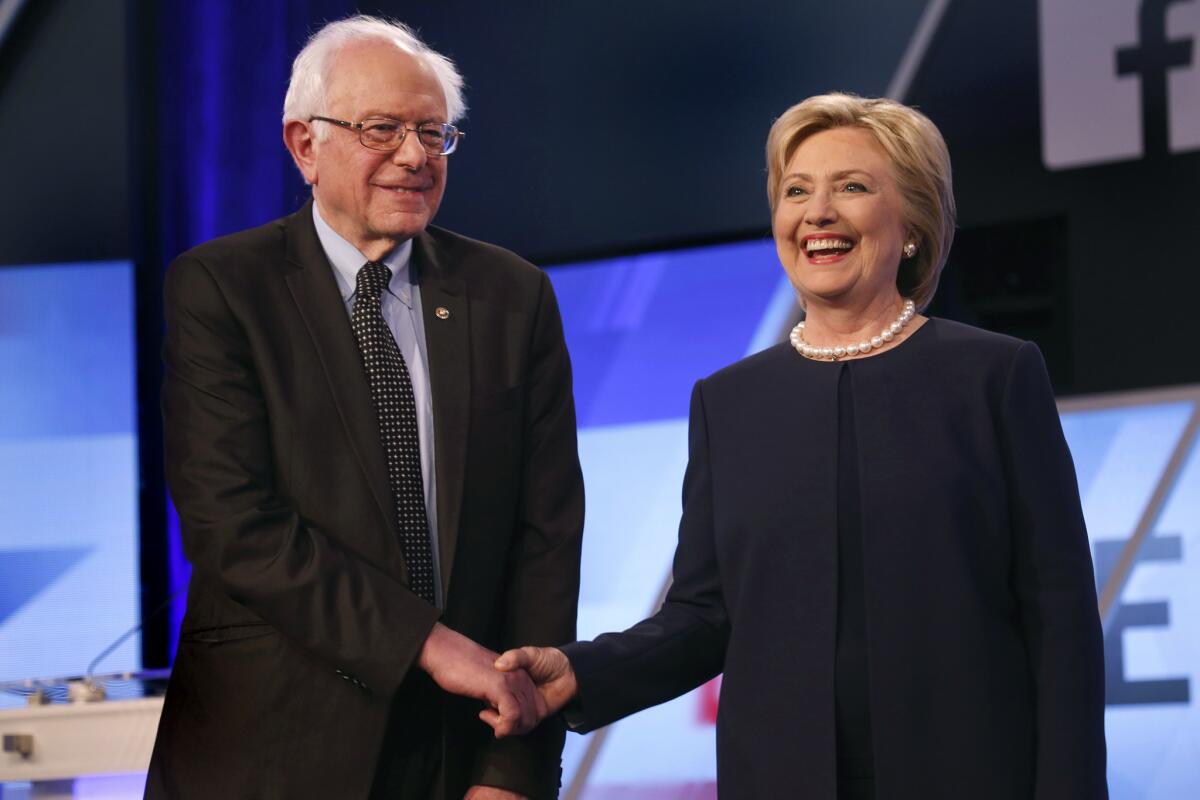Democratic presidential candidates Bernie Sanders and Hillary Clinton shake hands before the start of Wednesday's debate in Miami.