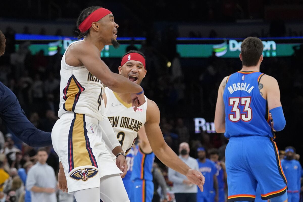 New Orleans Pelicans guard Devonte' Graham (4) celebrates with teammate Josh Hart (3) after hitting the game winning basket to end the second half of an NBA basketball game against the Oklahoma City Thunder, Wednesday, Dec. 15, 2021, in Oklahoma City. (AP Photo/Sue Ogrocki)