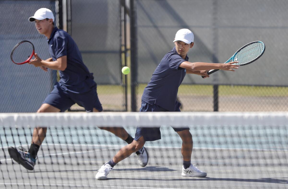 Marina's Bradley Gallo goes to the net, left, as playing partner Trevor Nguyen hits a forehand during Wednesday's match.