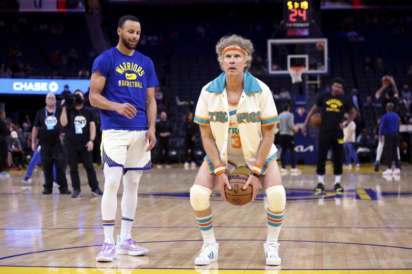 Actor Will Ferrell, right, warms up with Golden State Warriors guard Stephen Curry, left, before the team's NBA basketball game against the Los Angeles Clippers in San Francisco, Tuesday, March 8, 2022. (AP Photo/Jed Jacobsohn)