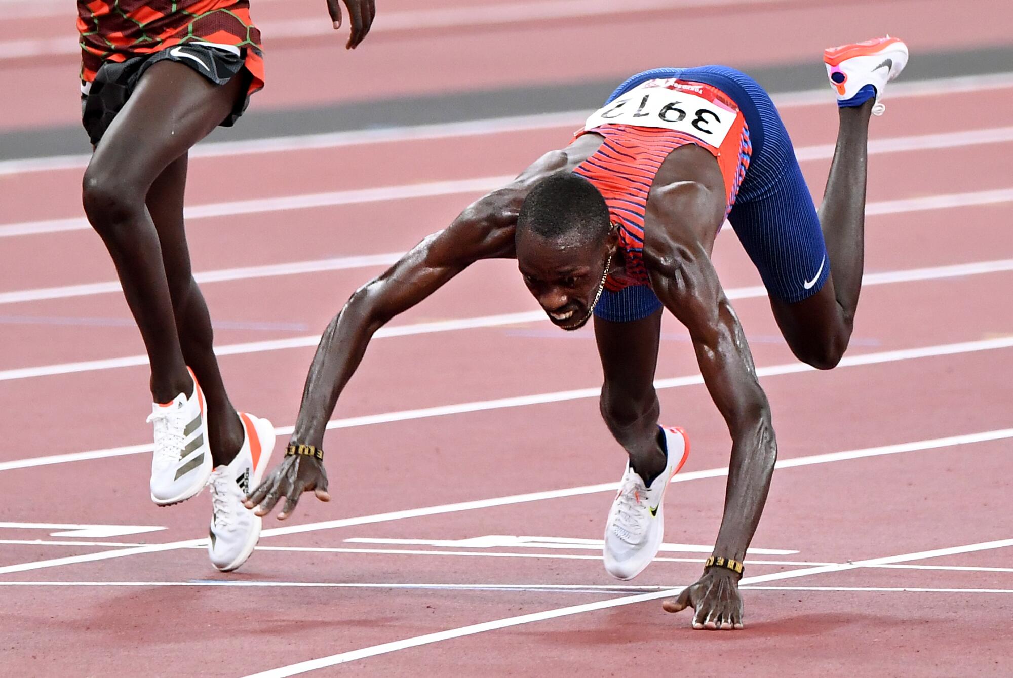 USA's Paul Chelimo falls across the finish line to win the bronze medal in the men's 5,000.