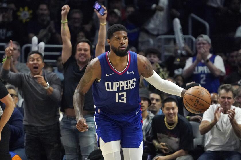 Los Angeles Clippers guard Paul George dribbles as fans cheer in the background during the first half of an NBA basketball game against the Utah Jazz Tuesday, March 29, 2022, in Los Angeles. (AP Photo/Mark J. Terrill)