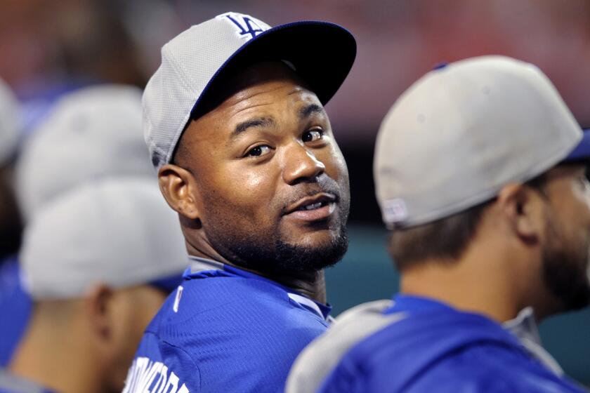 Dodgers outfielder Carl Crawford sits in the dugout during an exhibition game against the Angels at Angel Stadium on April 3.